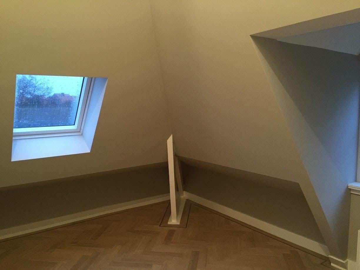 Finished attic room with rooflight, herringbone floor and sloping walls