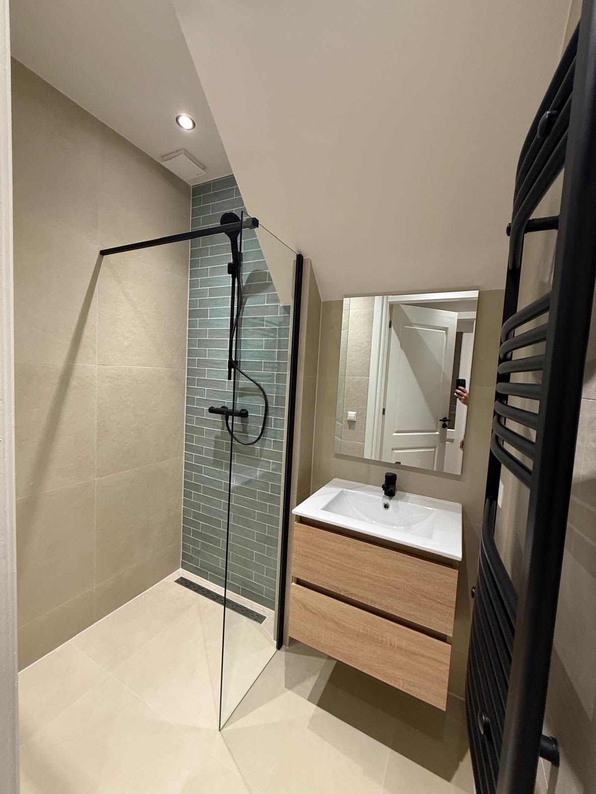 Renovated bathroom with walk-in shower, black fittings and a wood-look vanity unit