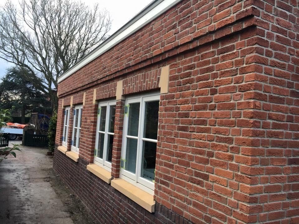 Brick side extension with white frames, stone sills and a neat roof edge