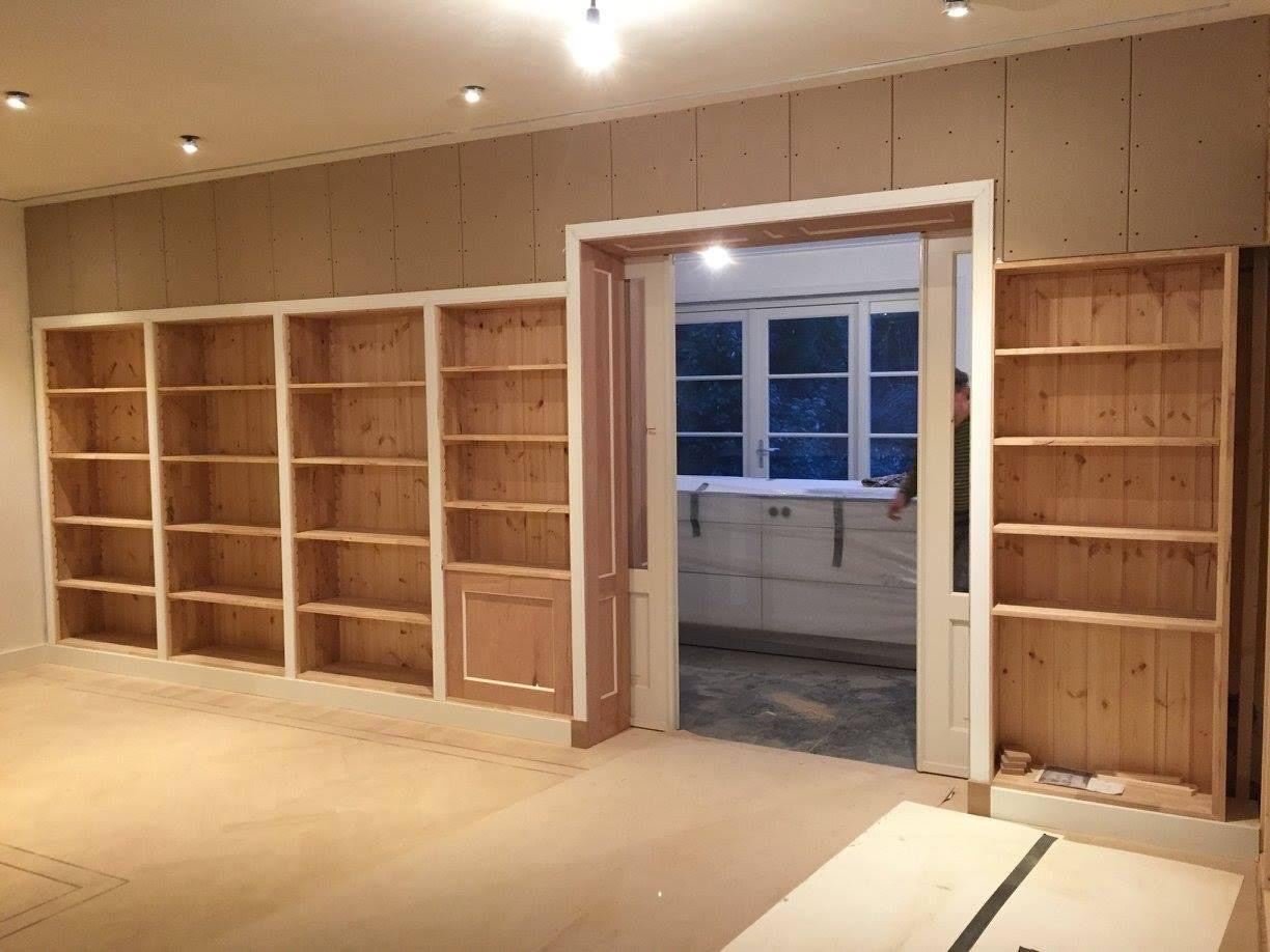 Built-in timber bookcases on both sides of a double doorway, before painting