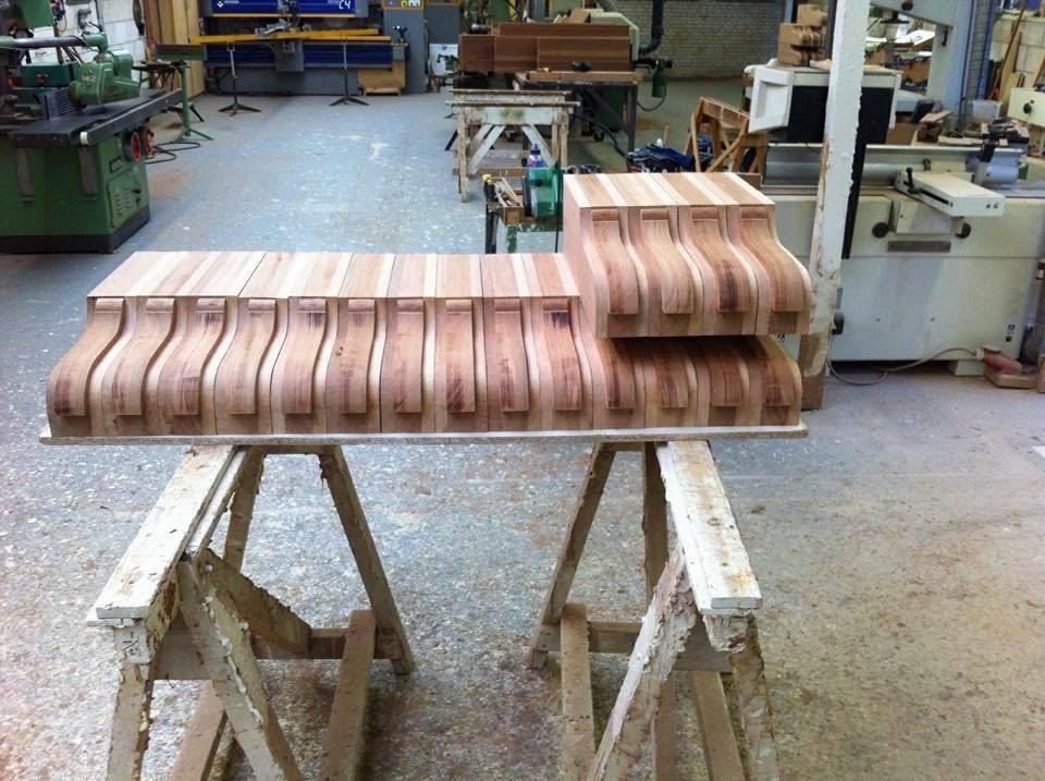 Handmade timber cornice with carved brackets on trestles in a carpentry workshop