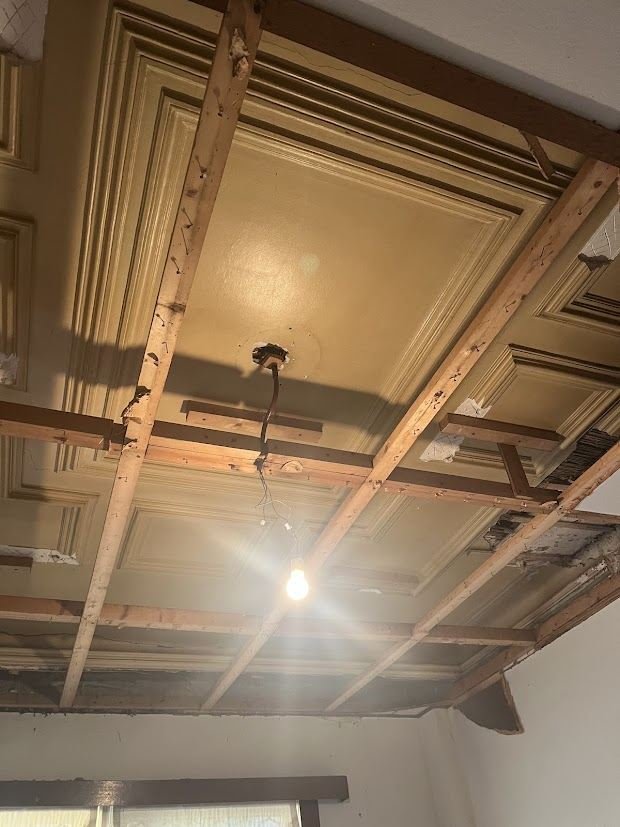 Old ceiling in a period home opened up, showing timber laths and the original cornice