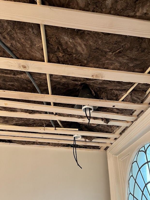Open ceiling with timber battens, insulation and cables for new lights