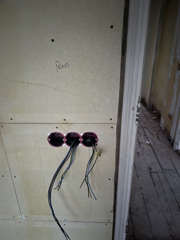 New electrical boxes and cables in a plasterboard wall before finishing