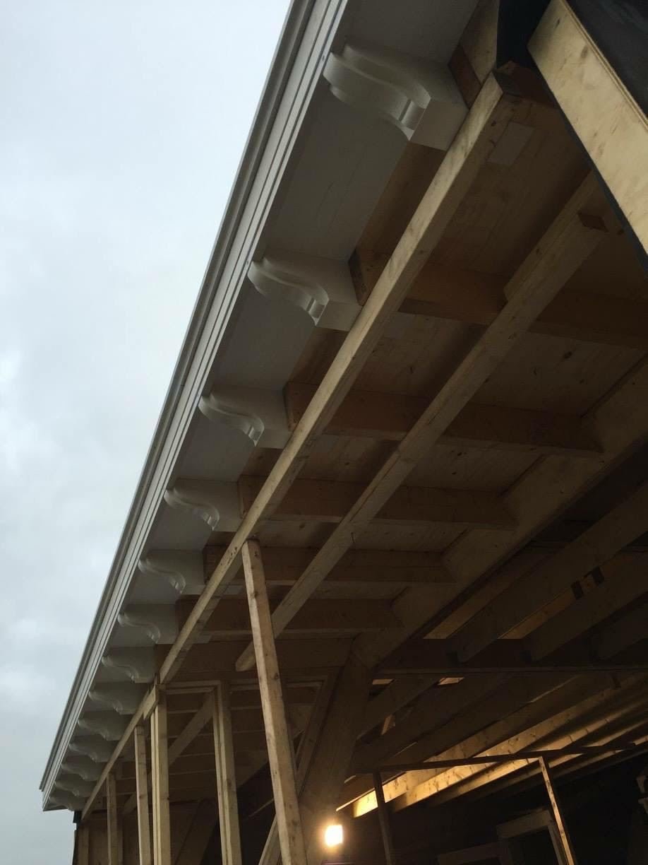 Timber roof framing and decorative brackets under the roof edge of a new extension