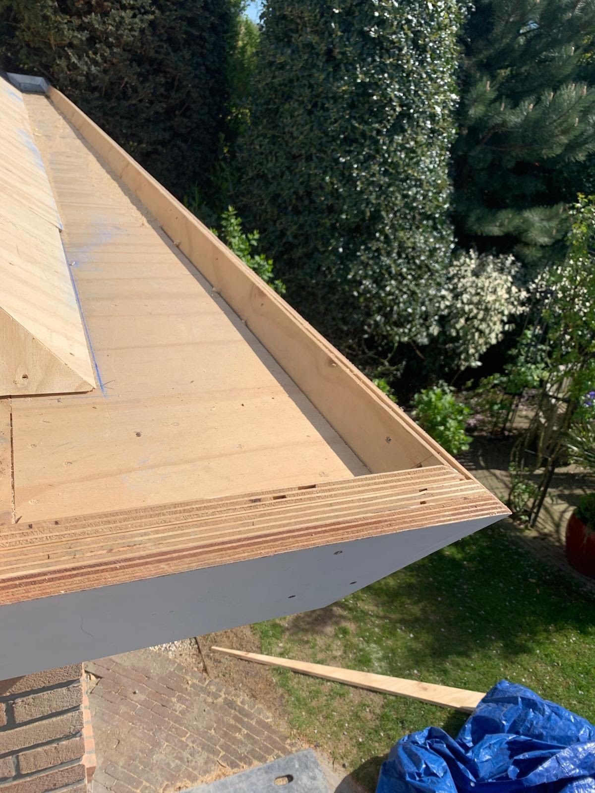New flat roof with timber edge and fascia, seen from above with the garden below