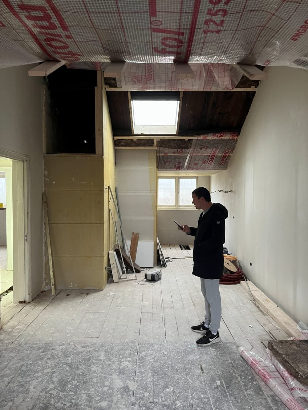 Joost on site in an attic under renovation, with the roof being insulated