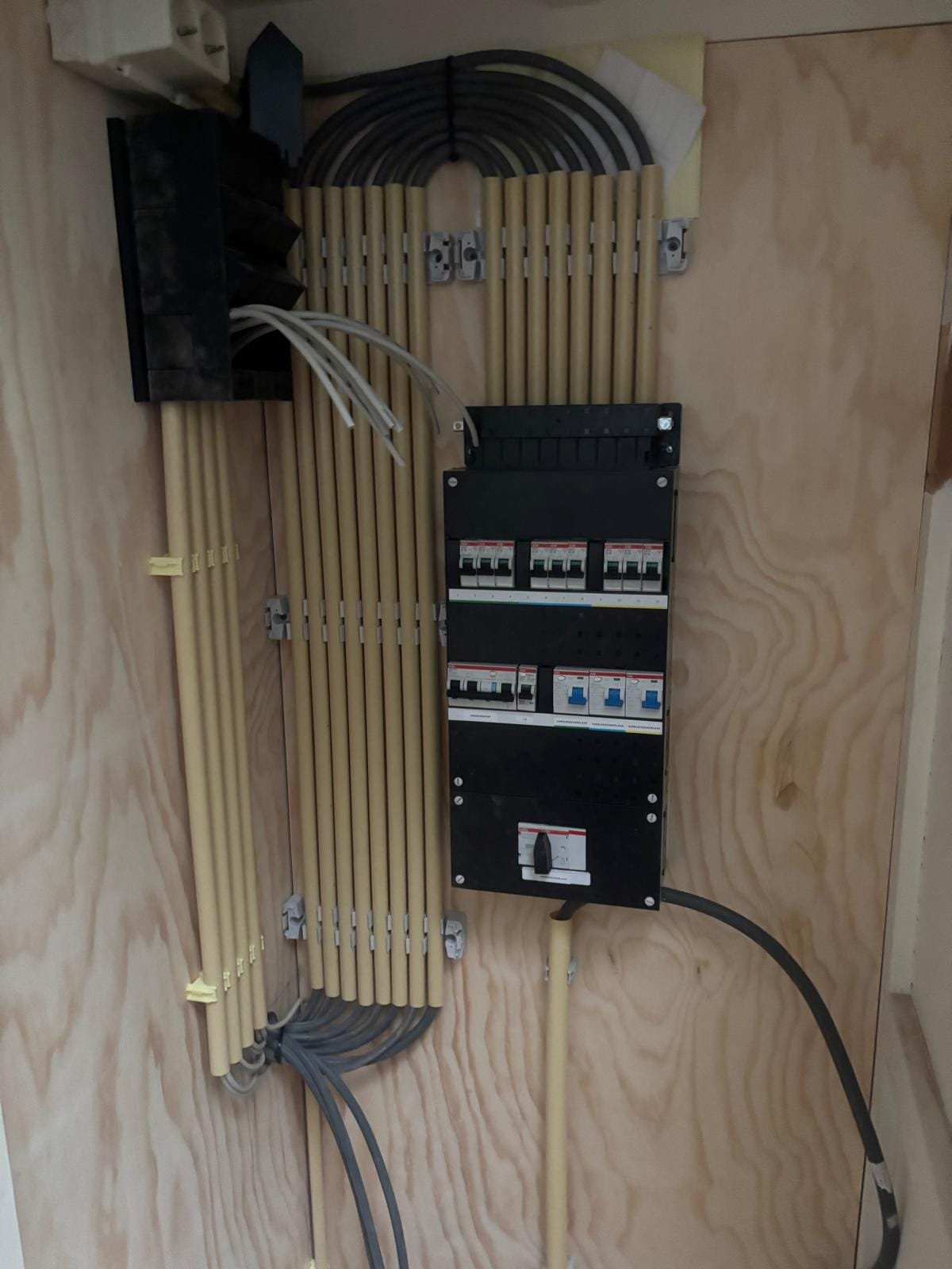 New fuse box with neatly routed cable conduits on a timber board