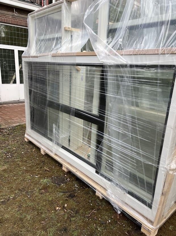 New made-to-measure window frames wrapped in plastic, delivered on a pallet