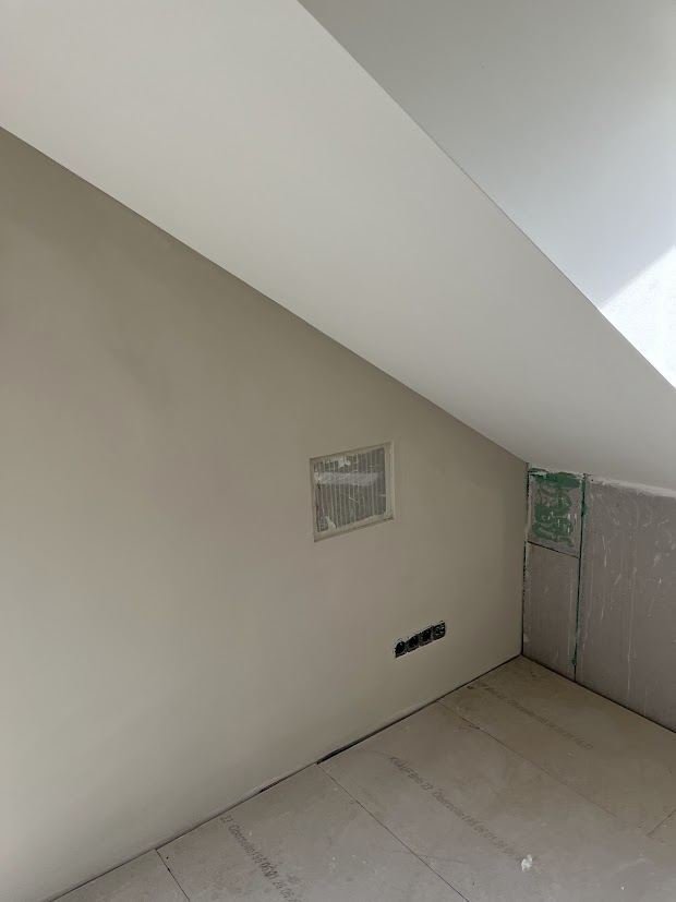 Freshly plastered attic wall and sloping ceiling with rooflight