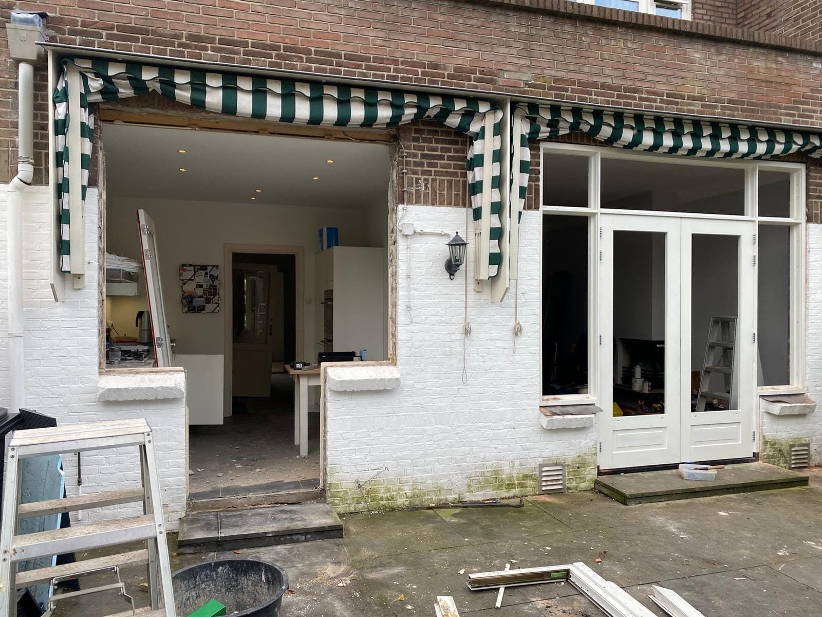 Rear facade of a period home with the old frames removed and the kitchen visible through the opening