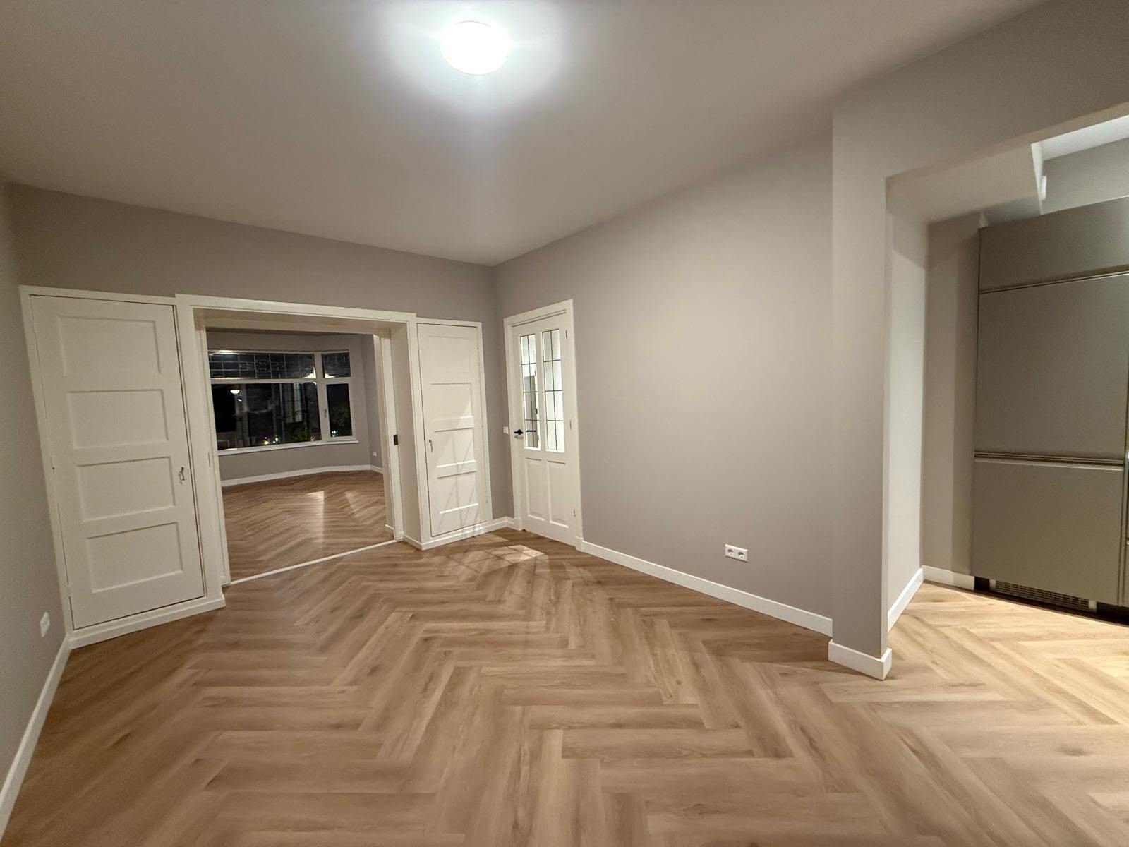 Renovated living room with herringbone floor, panelled doors and fresh paintwork